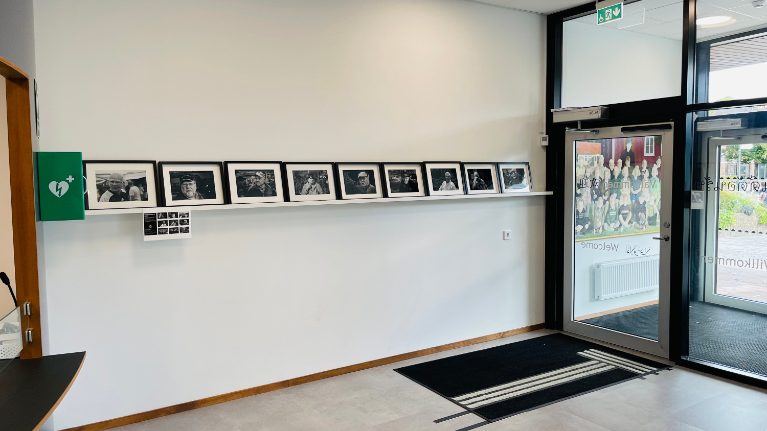 Foto från foajén i Centrumhuset där svartvita fotografier visas på en tavellist