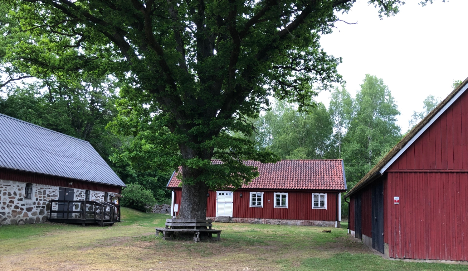 Exteriör Hagstadgården - Artur Lundkvist födelsegård. Röd bostadsbyggnad med ladugårdsbyggnader intill.