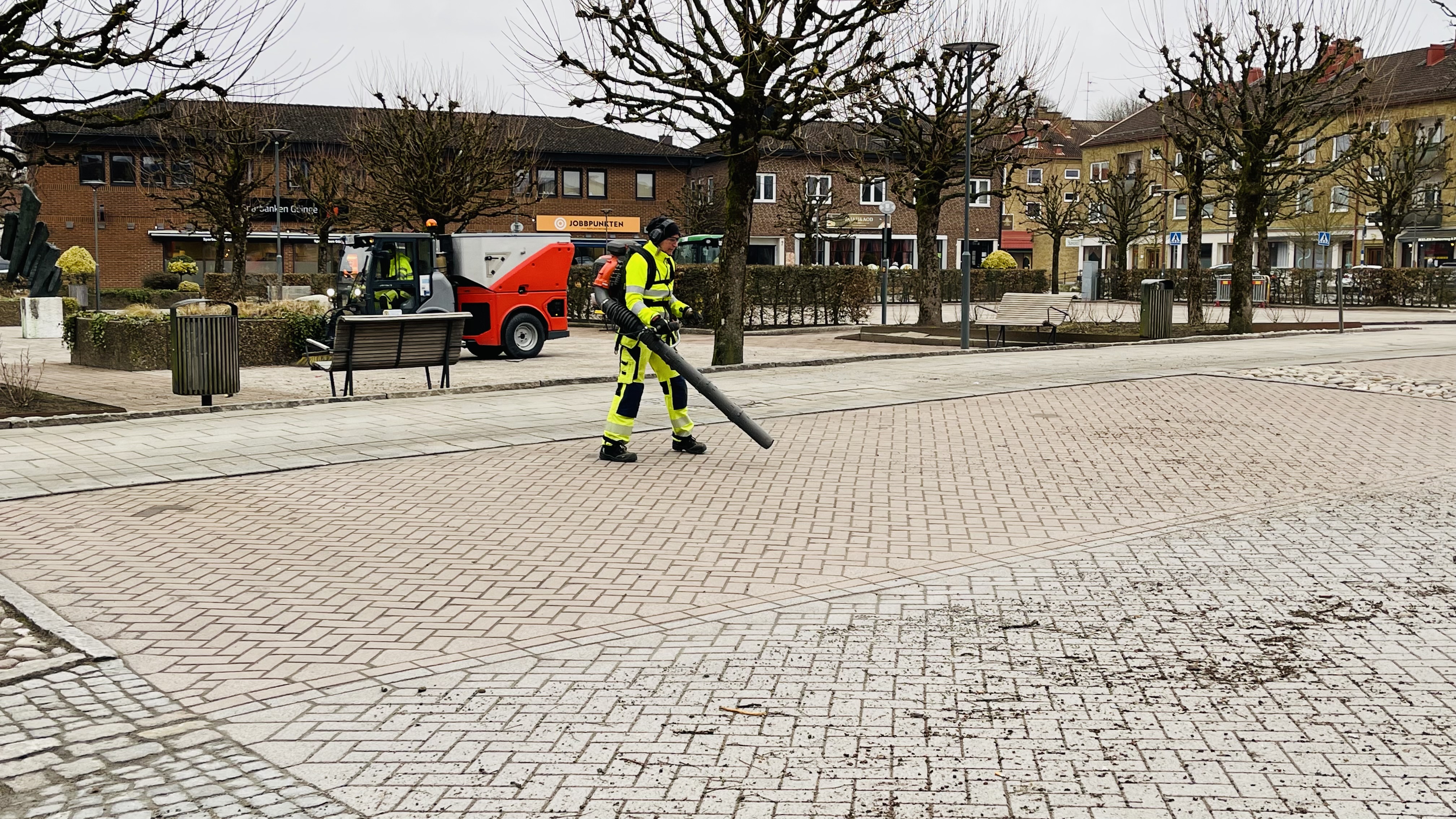 Personal blåser löv och grus på gator och torg.