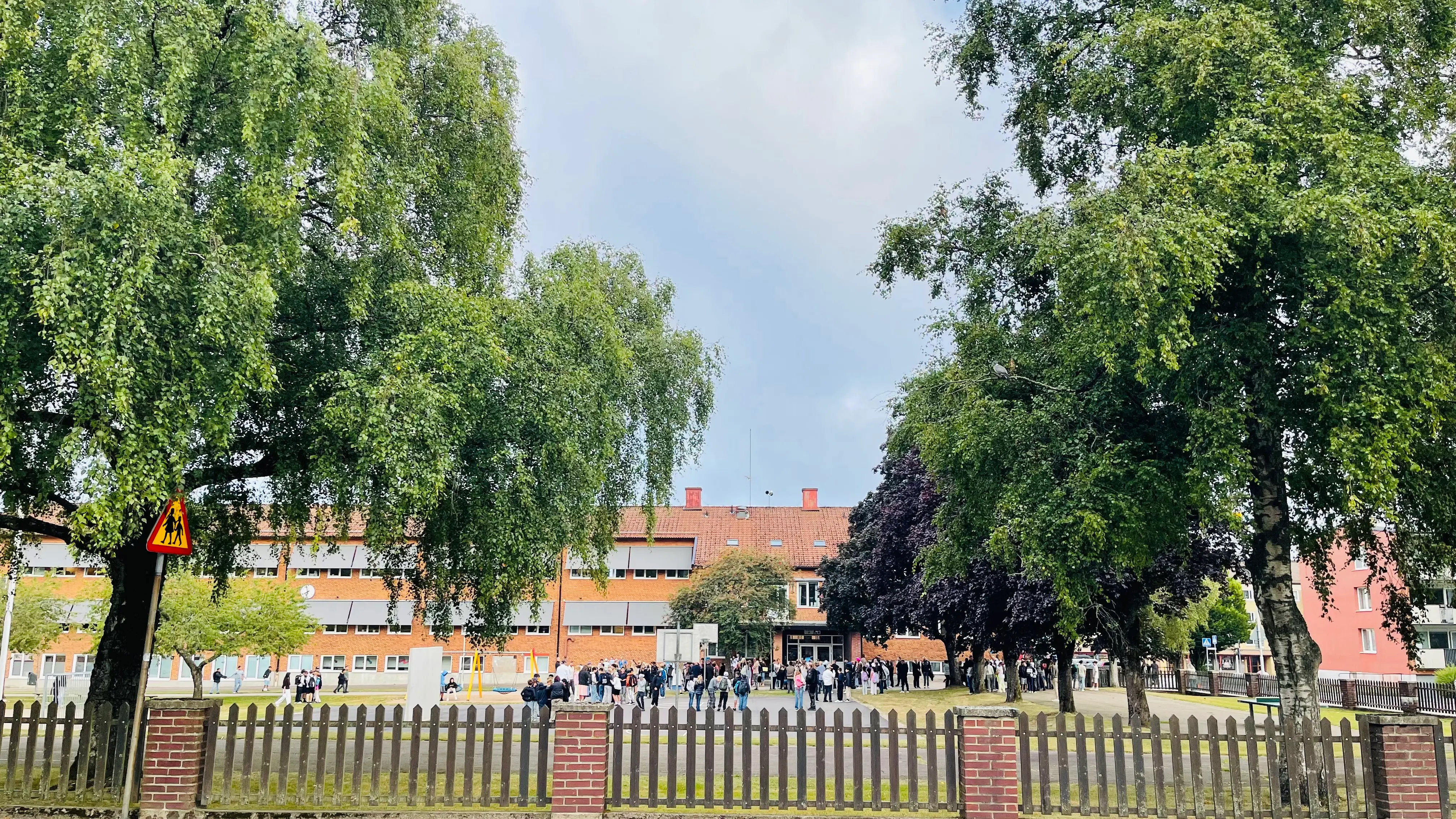 Personer samlade utanför skolbyggnad