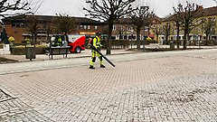 Personal blåser löv och grus på gator och torg.